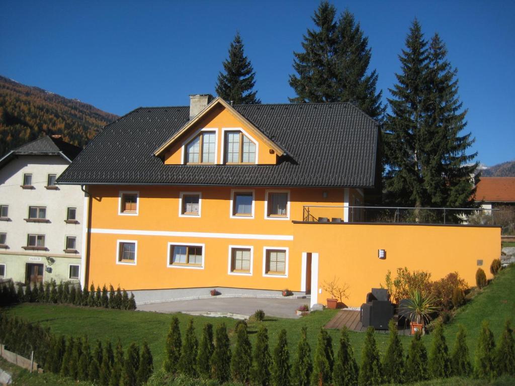 a yellow house with a black roof at Ferienwohnung Mohr in Sankt Michael im Lungau