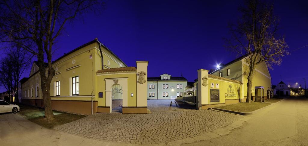 a group of buildings in a parking lot at night at Hotel Purkmistr in Plzeň