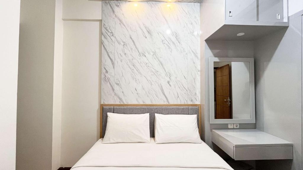 PampangにあるBest Price 2BR Apartment Vida View Makassar By Travelioのベッドルーム(ベッド1台、鏡付)
