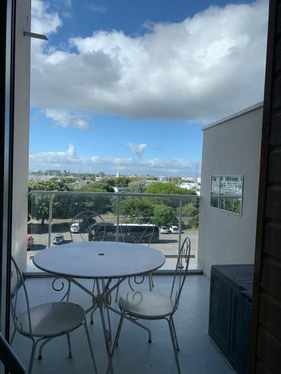 a table and chairs on a balcony with a view at appt Grand Voile in La Rochelle