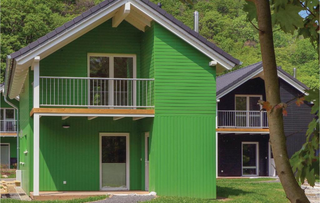 a green house with a balcony on top of it at Ferienhausdorf Thale in Thale
