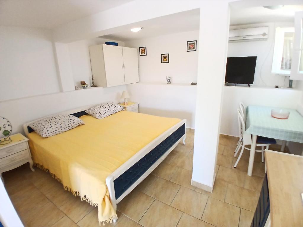 sypialnia z żółtym łóżkiem i stołem w obiekcie Apartments Neo w mieście Rukavac