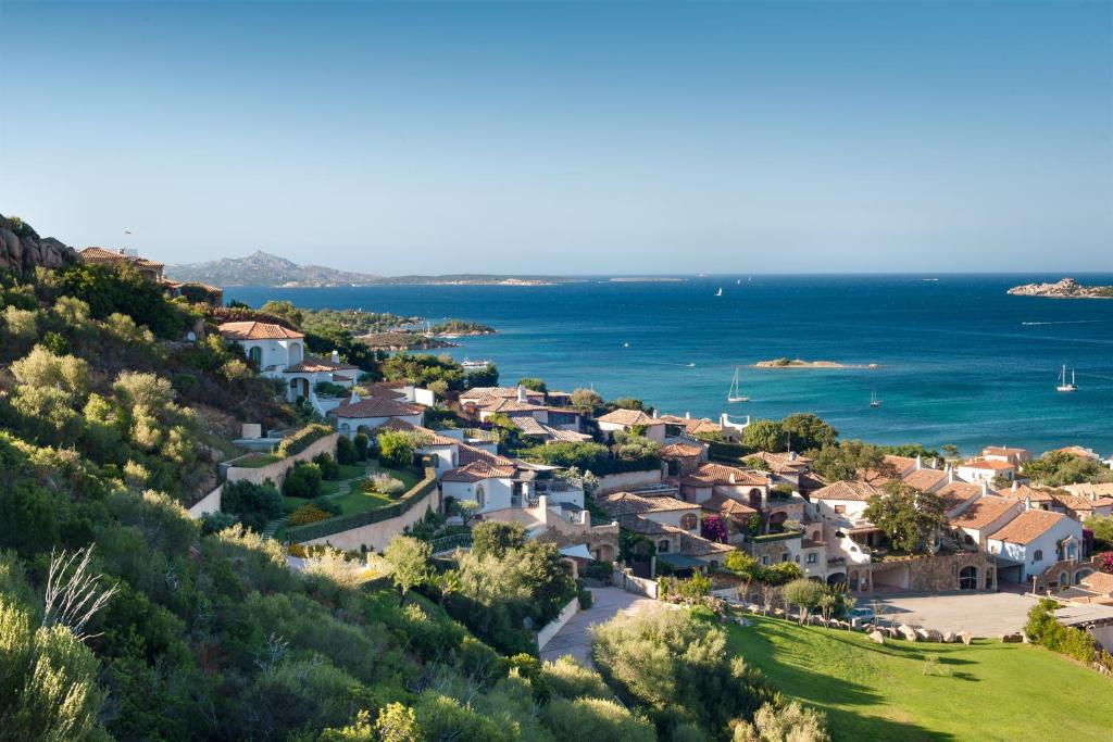 an aerial view of a village on a hill next to the ocean at Aethos Sardinia in Cannigione