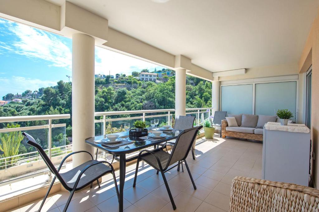 a dining room with a table and chairs on a balcony at BEAUSEJOUR - Splendide 2 pièces - Piscine - Parking - Vue mer in Beausoleil