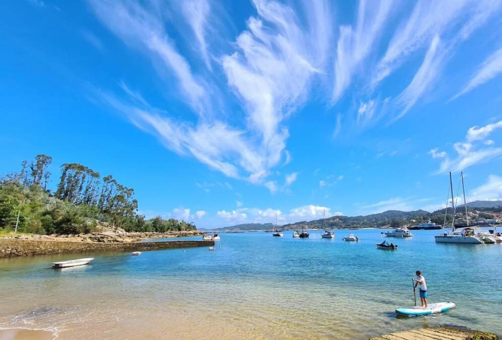 eine Person, die auf einem Paddelbrett im Wasser steht in der Unterkunft Casa con jardín a un minuto de la playa, Casa Nolo in Hio