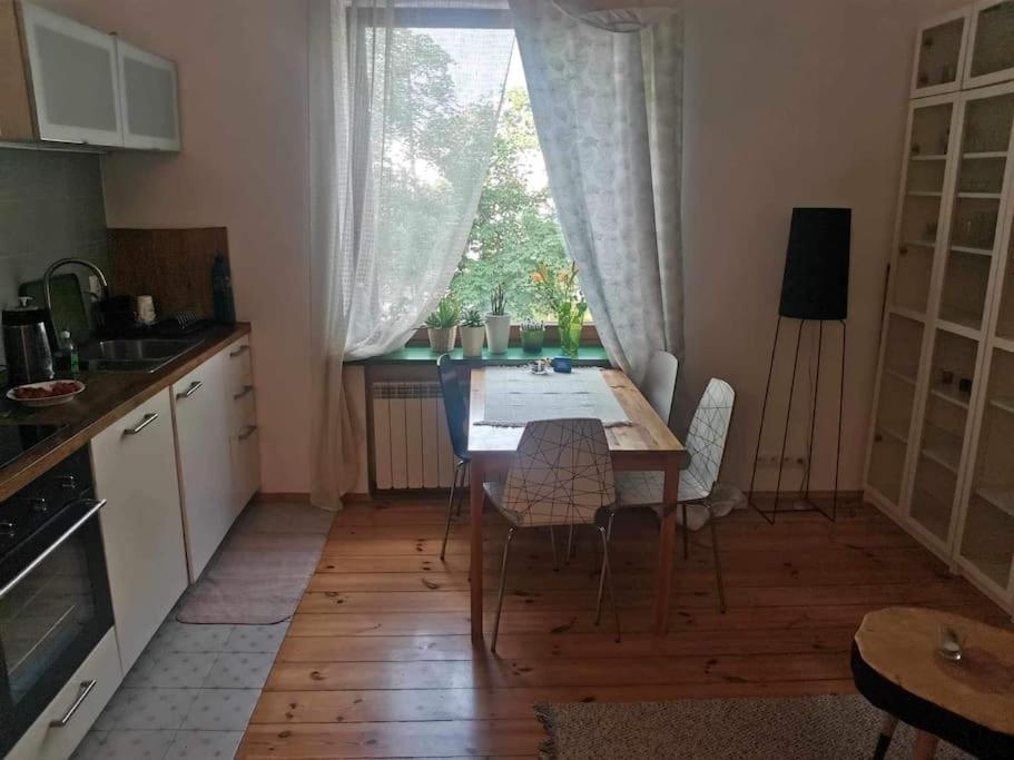 Una cocina con mesa y sillas y una ventana. en Green Apartament Żoliborz, en Varsovia
