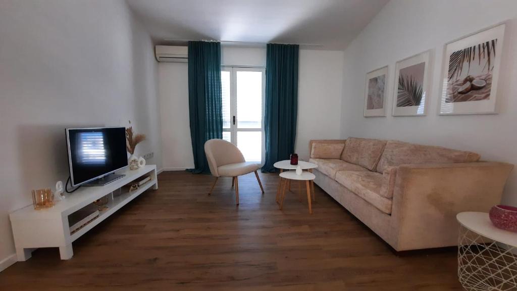 a living room with a couch and a tv at Apartments Ruzica in Makarska
