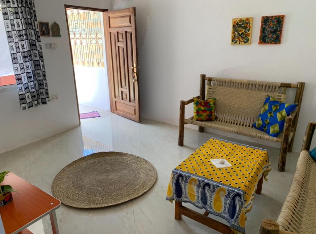 a living room with a table and a chair at Paje Haven in Paje