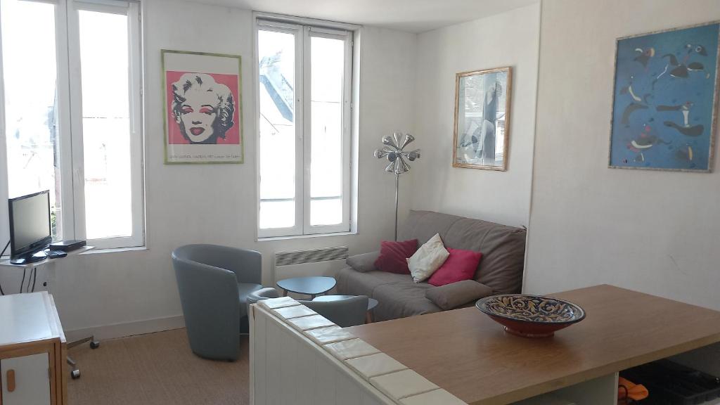 un salon avec un canapé et une table dans l'établissement deauville morny plein centre, à Deauville