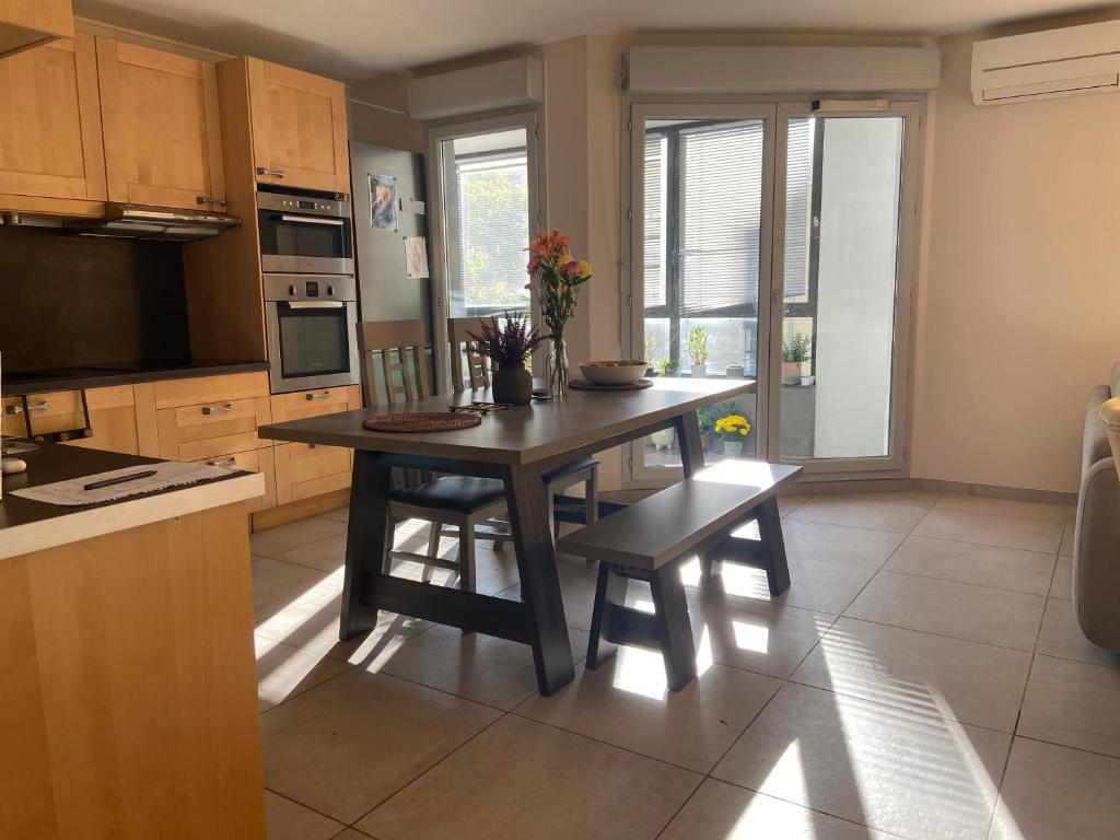 une cuisine avec une table en bois et une salle à manger dans l'établissement Appartement de standing - 3 chambres - 8 personnes - Grand Lyon, à Villeurbanne