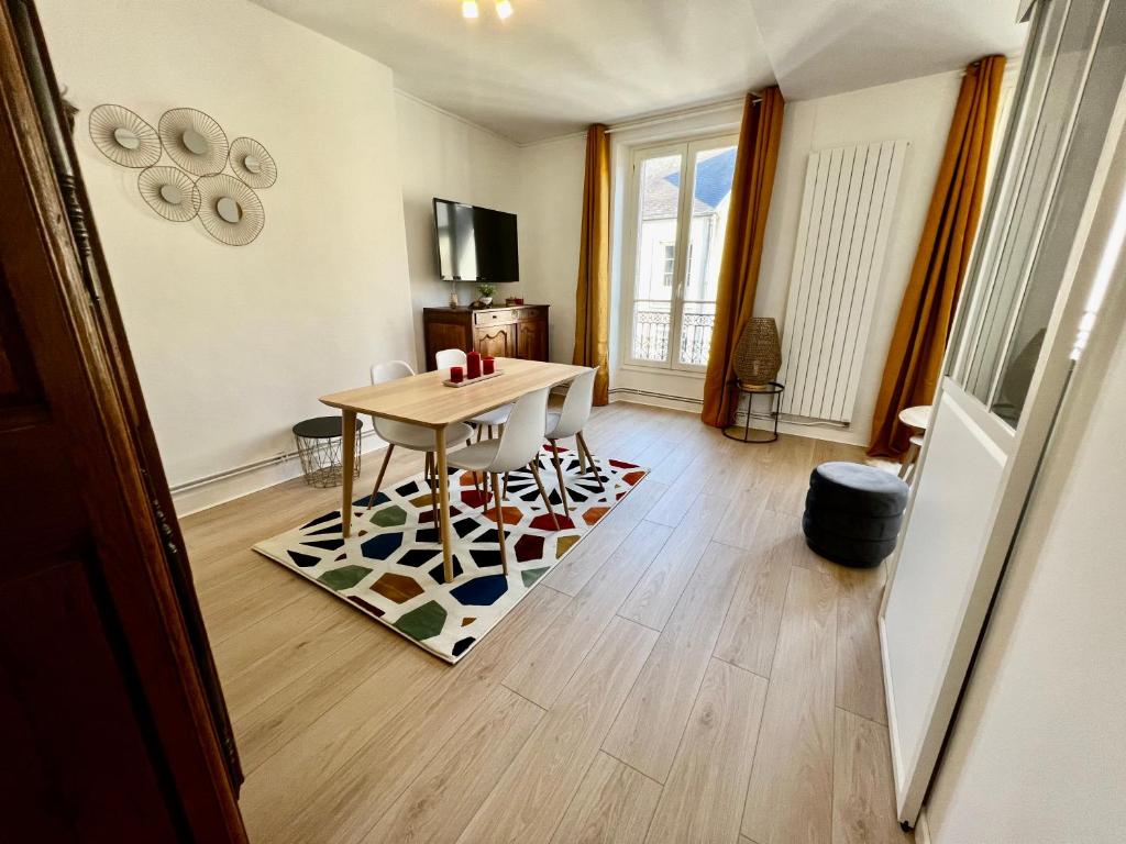 - un salon avec une table sur un tapis dans l'établissement EVA Bayeux, à Bayeux