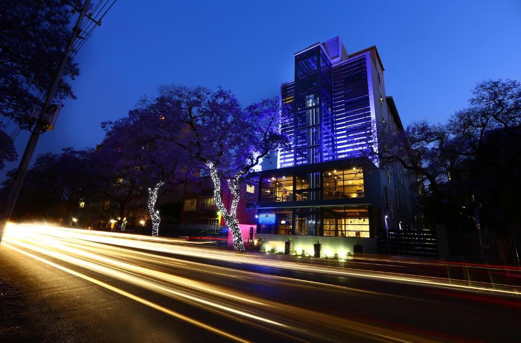 una calle de la ciudad con un edificio alto por la noche en Inani Hotel Morning Star en Pretoria