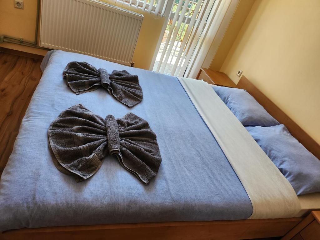 two bow ties on a bed in a bedroom at КЪЩА ЗА ГОСТИ ВОДЕНИЦАТА in Devin
