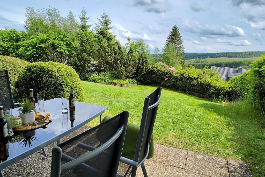 a table and chairs in a garden with a view at Ferienwohnung Wera -am Bikepark-Sauna in Winterberg