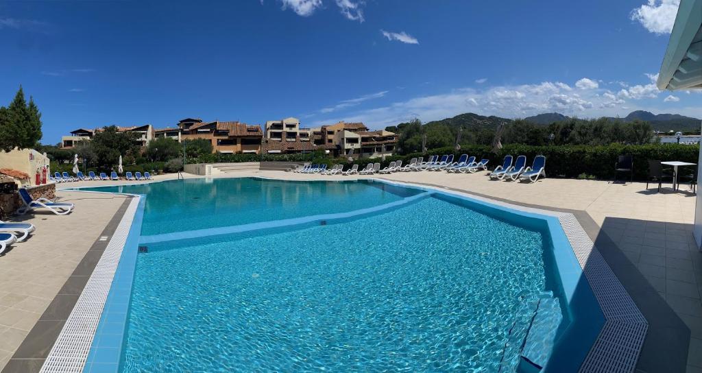 una grande piscina con sedie e un resort di Residence Portorotondo Asfodeli a Porto Rotondo