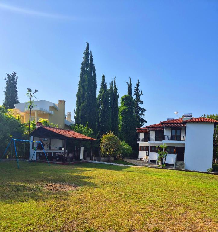 a yard with a house and a playground at GeoVilla Green & Blue 2 - Pefkochori in Pefkochori