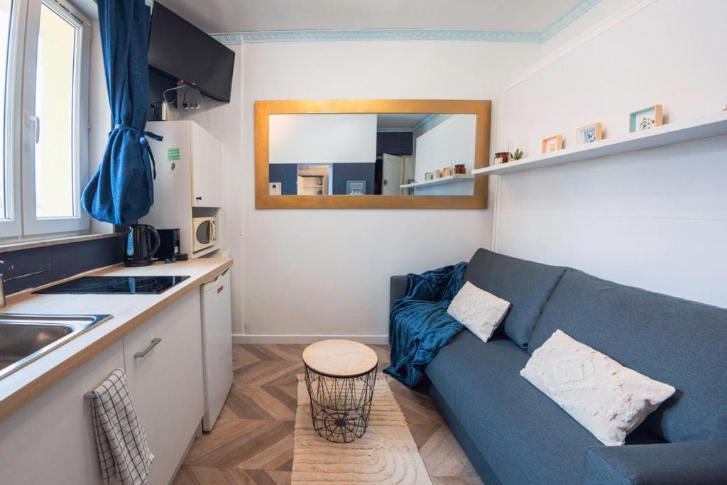 un soggiorno con divano blu in cucina di Studio cosy coeur du Touquet proche plage - Wifi a Le Touquet-Paris-Plage