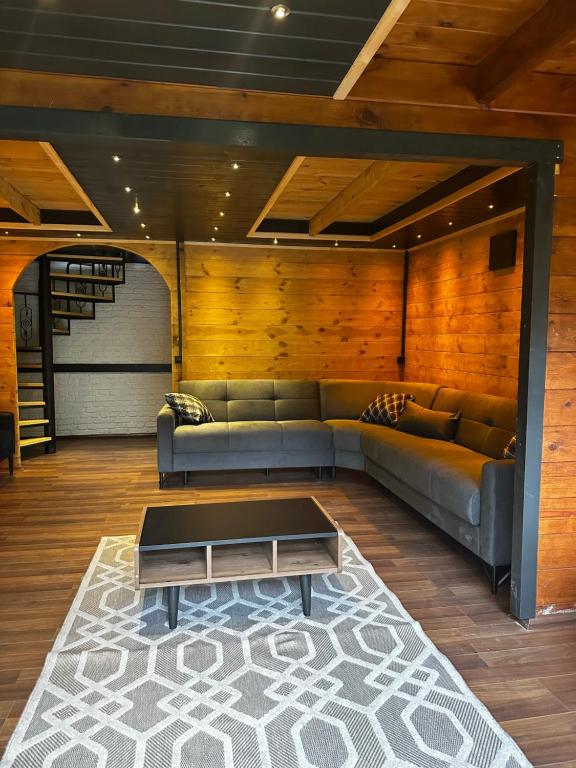 a living room with a couch and a coffee table at Tanura Bungalows in Çamlıhemşin