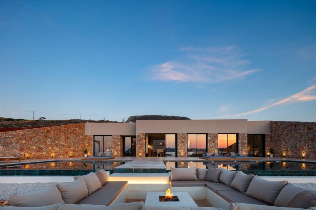 a villa with a swimming pool in front of a building at Dionysos Boutique Villa FirePit Heated Pool & Sauna in Kókkinon Khoríon