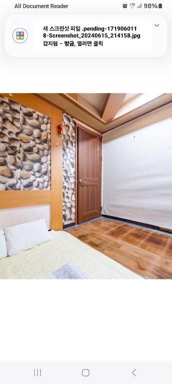 a bedroom with a bed and a stone wall at City Park Motel in Seongnam