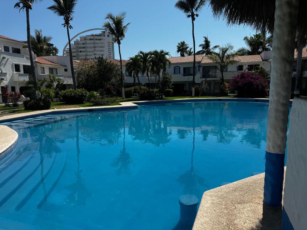 una gran piscina azul con palmeras en Casa Marina Turquesa 16 Personas, en Mazatlán