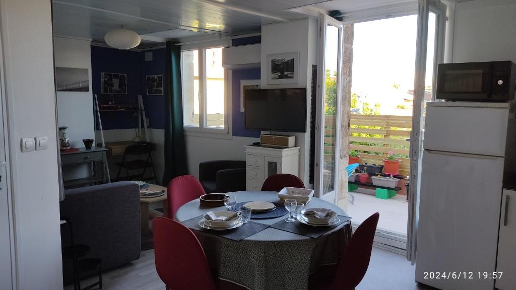 a living room with a table and red chairs at Les Bonbonieres d'Andrea Gavinies Pellegrin in Bordeaux