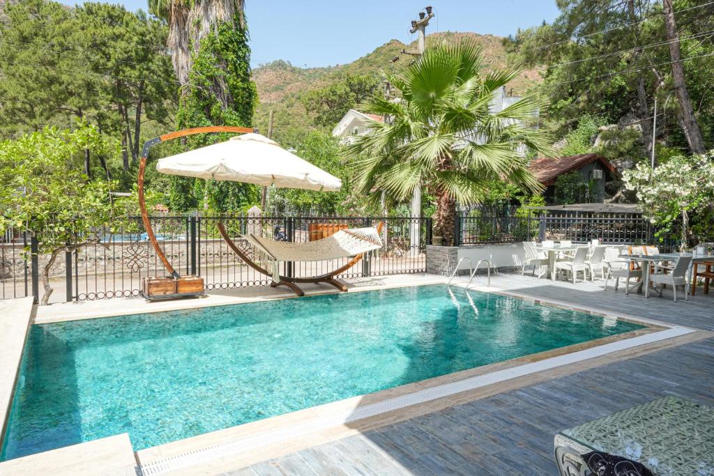 a swimming pool with a chair and an umbrella at ADA BOUTİQUE HOTEL in Marmaris
