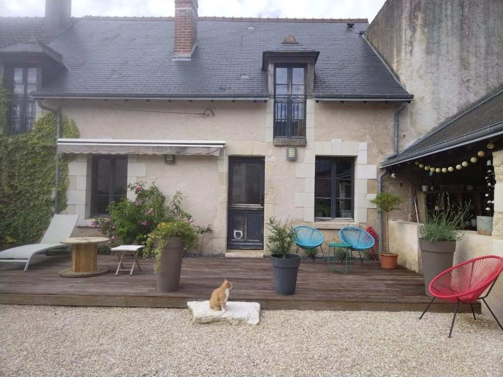 un chat assis sur une terrasse en bois devant une maison dans l'établissement Adorable maison tourangelle proche Amboise, à Souvigny-de-Touraine