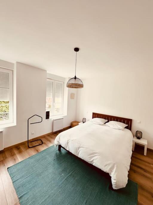- une chambre blanche avec un lit et un tapis vert dans l'établissement Studio Churchill hypercentre, à Charleville-Mézières