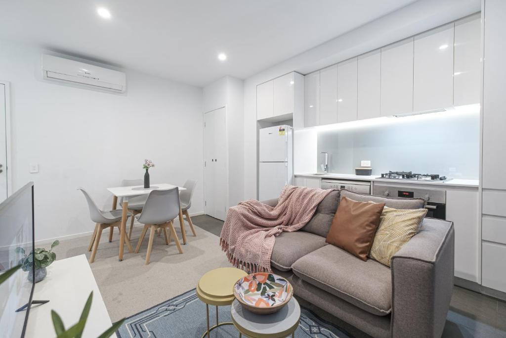 a living room with a couch and a table at Exquisite And Warm 1br Nest In Footscray Pool Gym in Melbourne