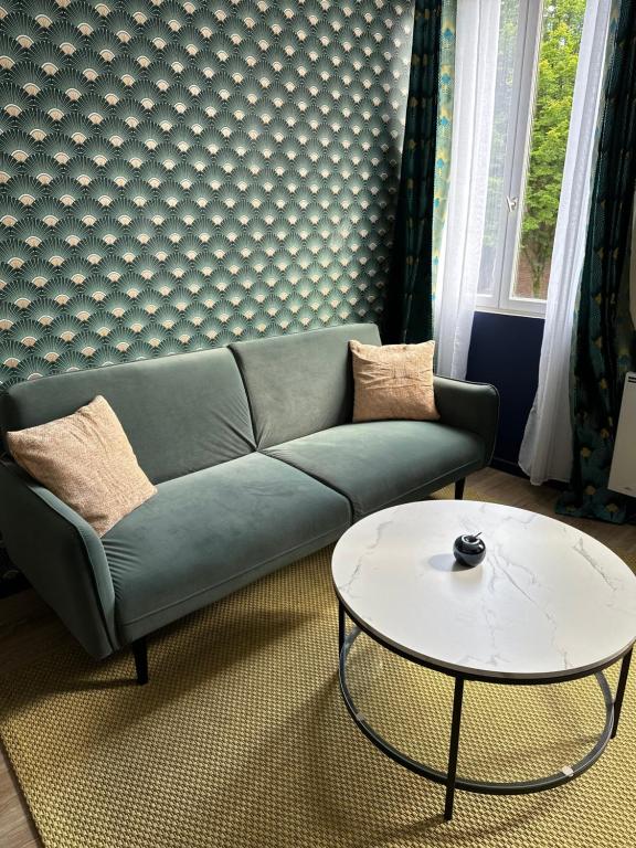 un salon avec un canapé et une table dans l'établissement Appartement entier cosy, à Rouen