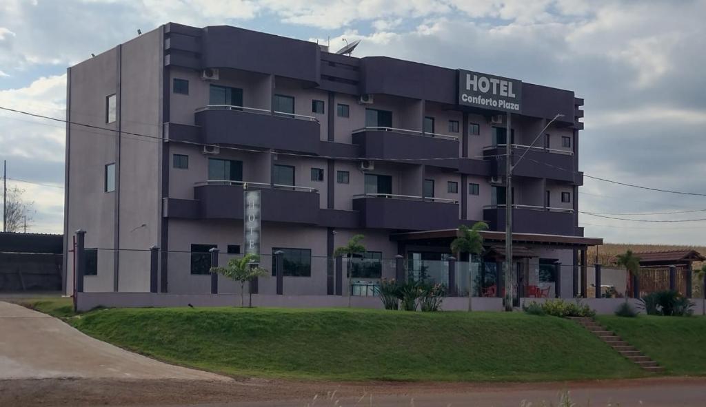 a hotel building with a sign on it at Conforto Plaza Hotel in Capitão Leônidas Marques