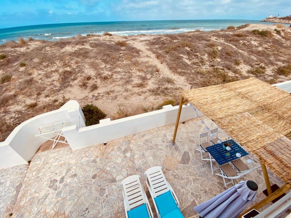 une vue aérienne d'une plage avec des chaises et l'océan dans l'établissement La Juanita - Dosel, à Faro de Cullera