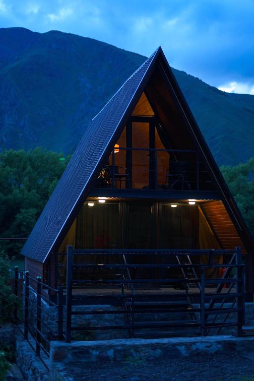 a cabin with a staircase in front of a mountain at Savalley Kazbegi in Kazbegi