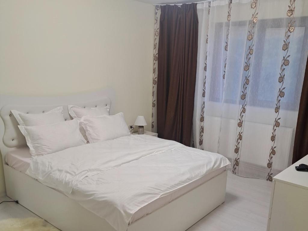 a bed with white sheets and pillows in a bedroom at Apartament Teo in Iaşi