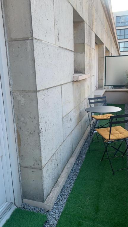une pièce avec des tables et des chaises et un mur avec de l'herbe verte dans l'établissement Rouen centre, à Rouen