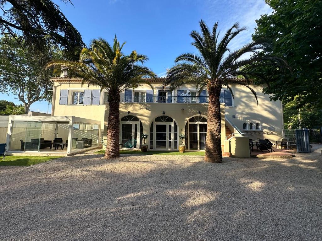 une maison avec deux palmiers devant elle dans l'établissement Le refuge du littoral n8, à Grimaud
