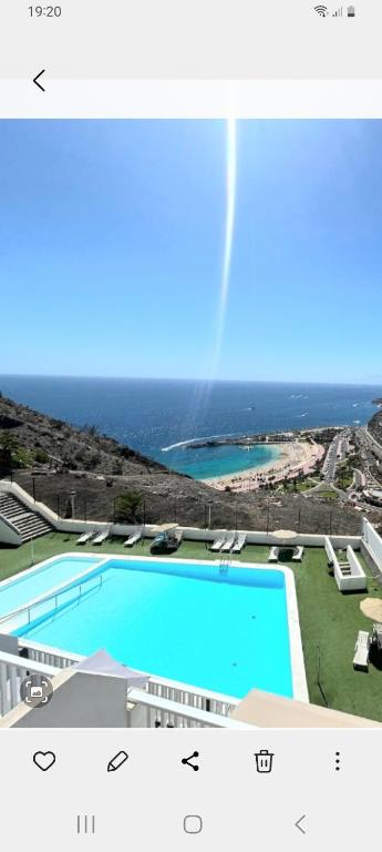a large swimming pool with the ocean in the background at Sandra Amadores in Puerto Rico de Gran Canaria