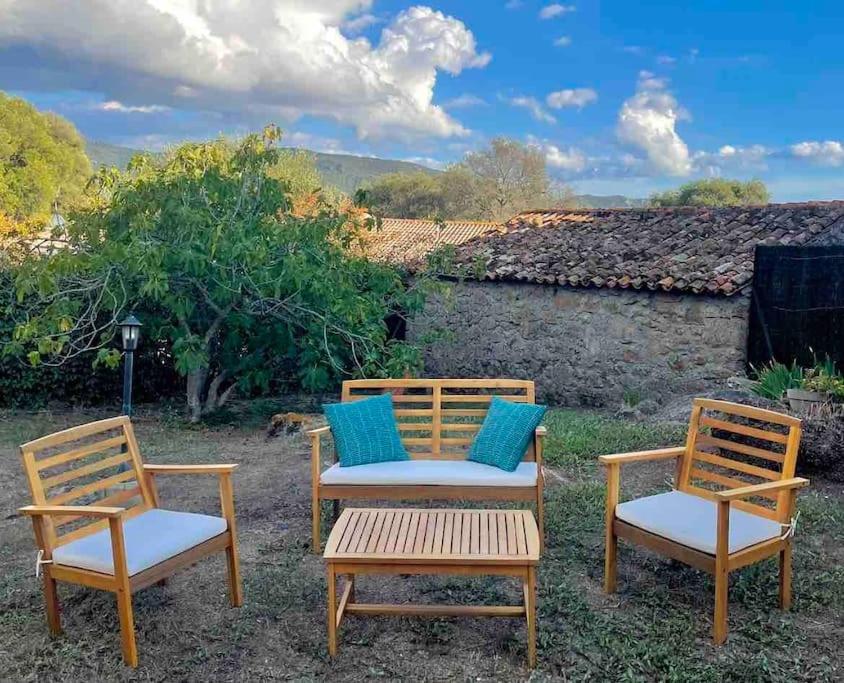 3 chaises et une table avec des oreillers bleus dans l'établissement Premier étage d'une maison de campagne avec jardin, à Serra-di-Ferro