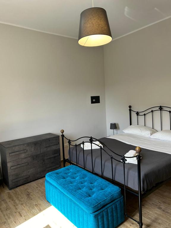 a bedroom with a bed with a blue ottoman at Villa Nobile in Siracusa