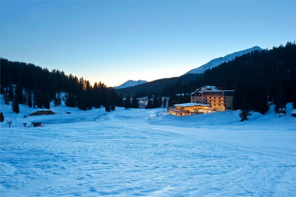 a building in the middle of a snow covered field at TH Madonna di Campiglio | Golf Hotel in Madonna di Campiglio