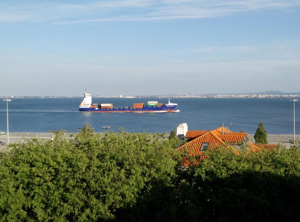 a large container ship sailing in the water at Xavier - Alfama Apartment River View in Lisbon