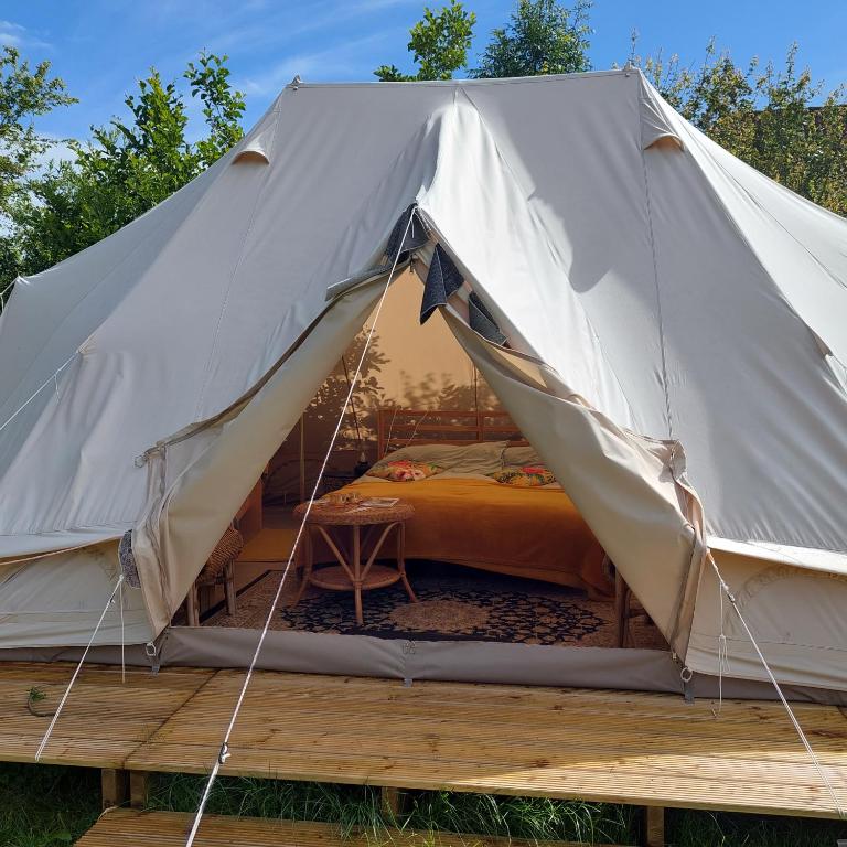 a canvas tent with a bed in it at Bell tent Glamping Essenhof in Aagtekerke