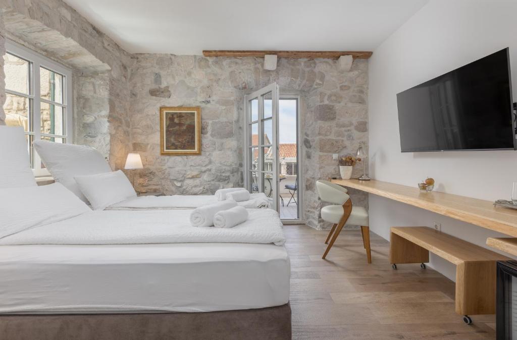 a bedroom with two beds and a desk with a television at NEW - Casa Columba - 4 Star Design Boutique Hotel with Outdoor Pool & Private Garden in Makarska