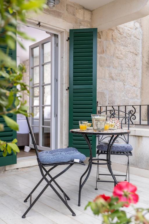 a table and chairs on a patio with a green door at NEW - Casa Columba - 4 Star Design Boutique Hotel with Outdoor Pool & Private Garden in Makarska