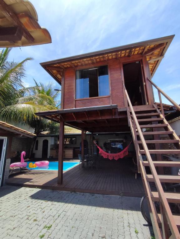 a house with a staircase leading up to a pool at Edícula acolhedora in Serra