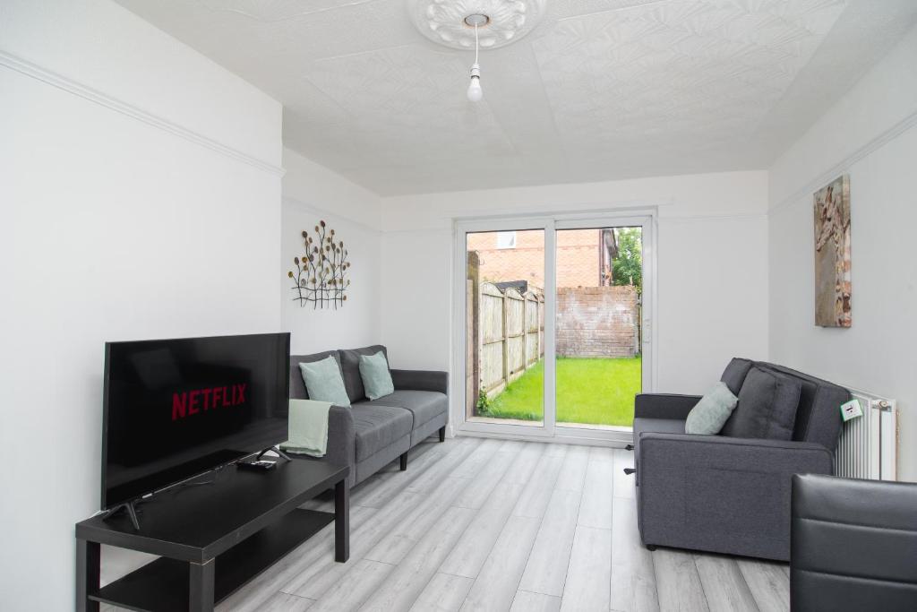 Una sala de estar con dos sofás y un televisor de pantalla plana. en Quiet 3 bed house, pet friendly, en Kirkby
