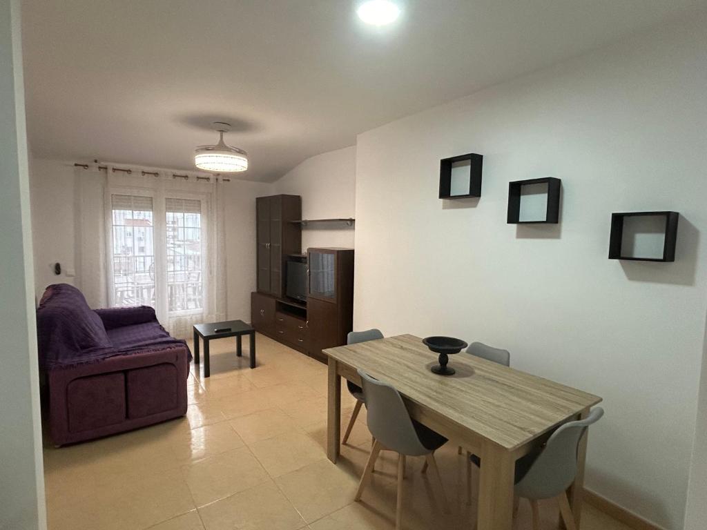 a living room with a table and a couch at Atico in Tomelloso