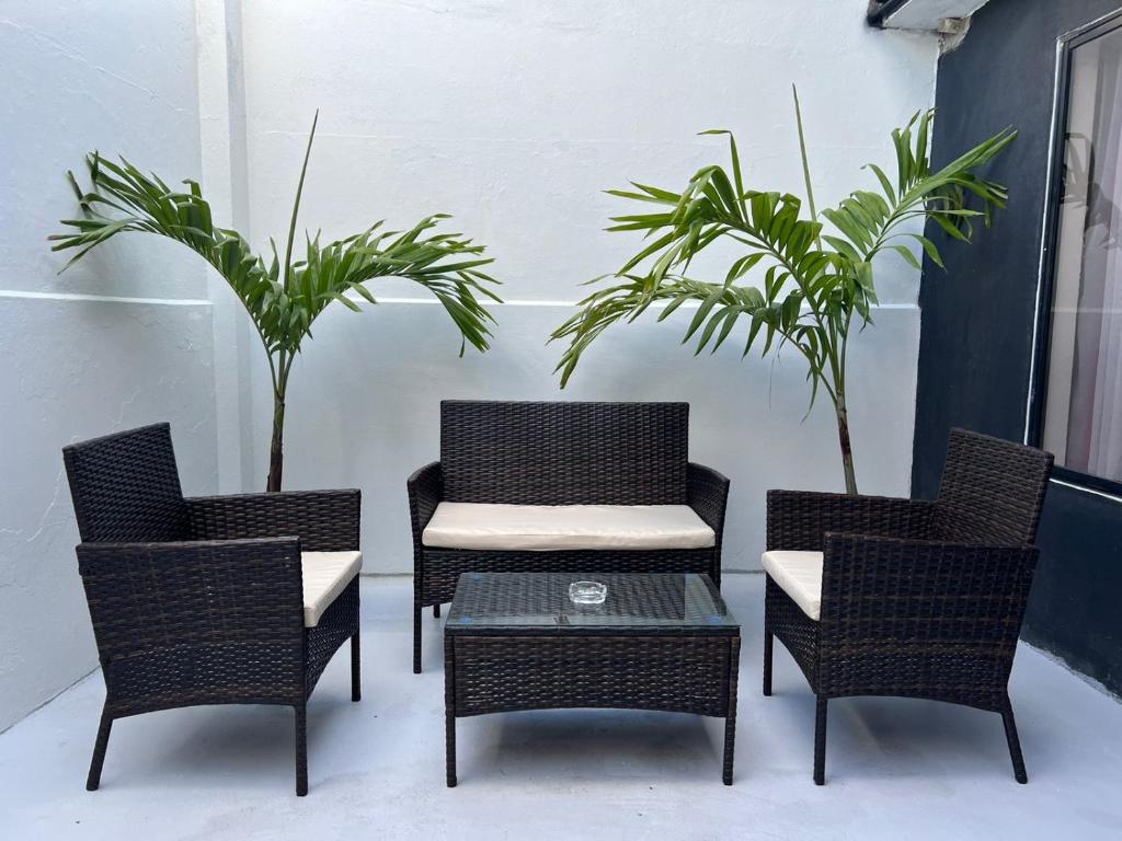 three chairs and a table and a table and two plants at Tourits Logde 2 bedroom 2 badroom in Baños