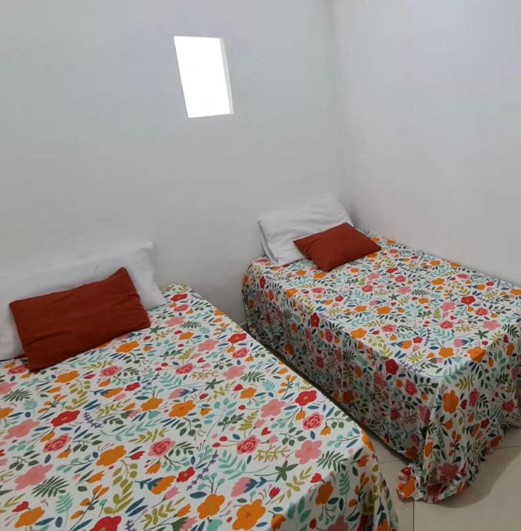 two beds sitting next to each other in a room at Hostel & Pousada SANTOS PRAIA in Santos